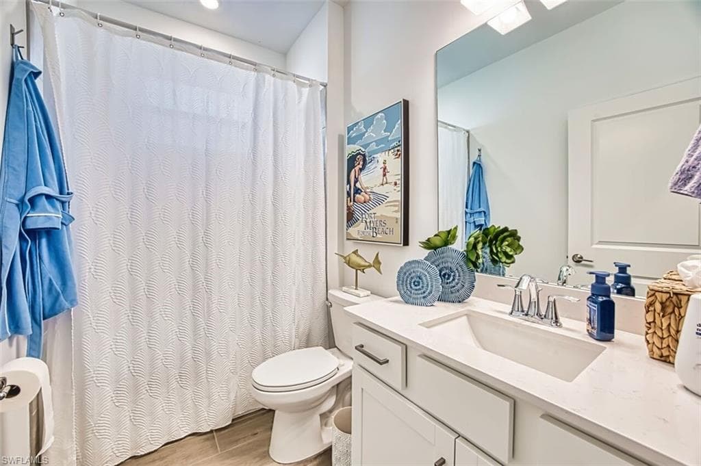 Bathroom with vanity, curtained shower, and light wood-style flooring