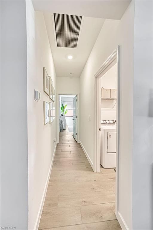 Corridor featuring light wood finished floors, washer / dryer, and recessed lighting