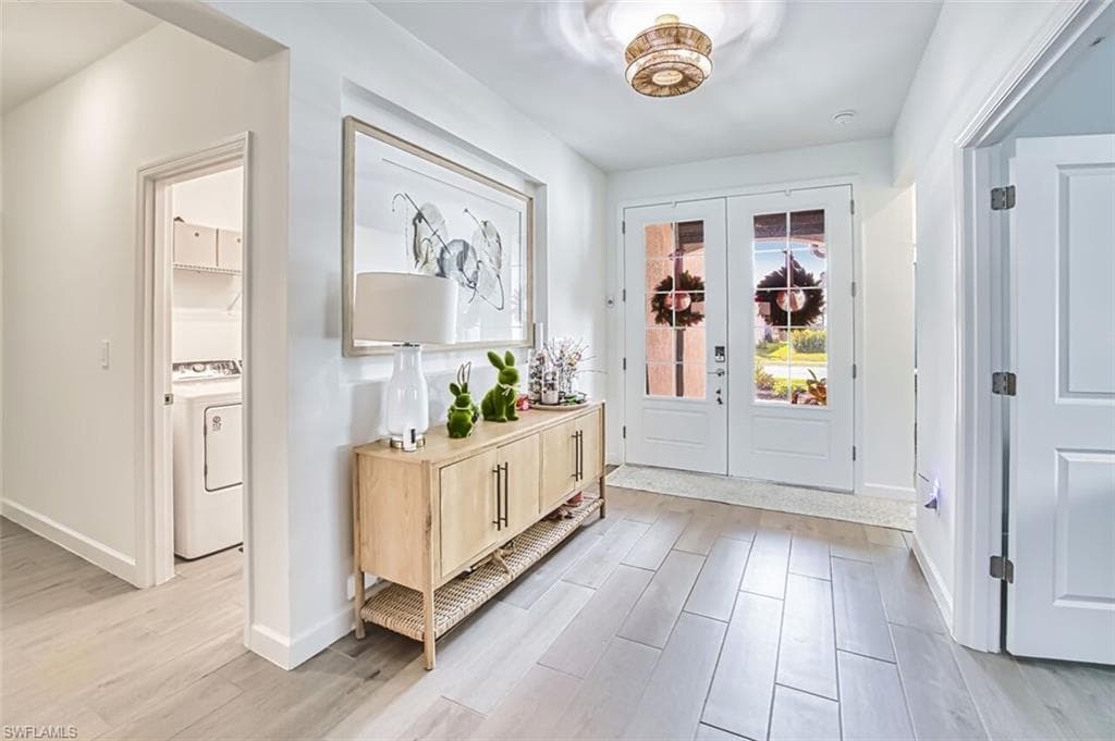 Entryway featuring wood finish floors, french doors, and washer / dryer