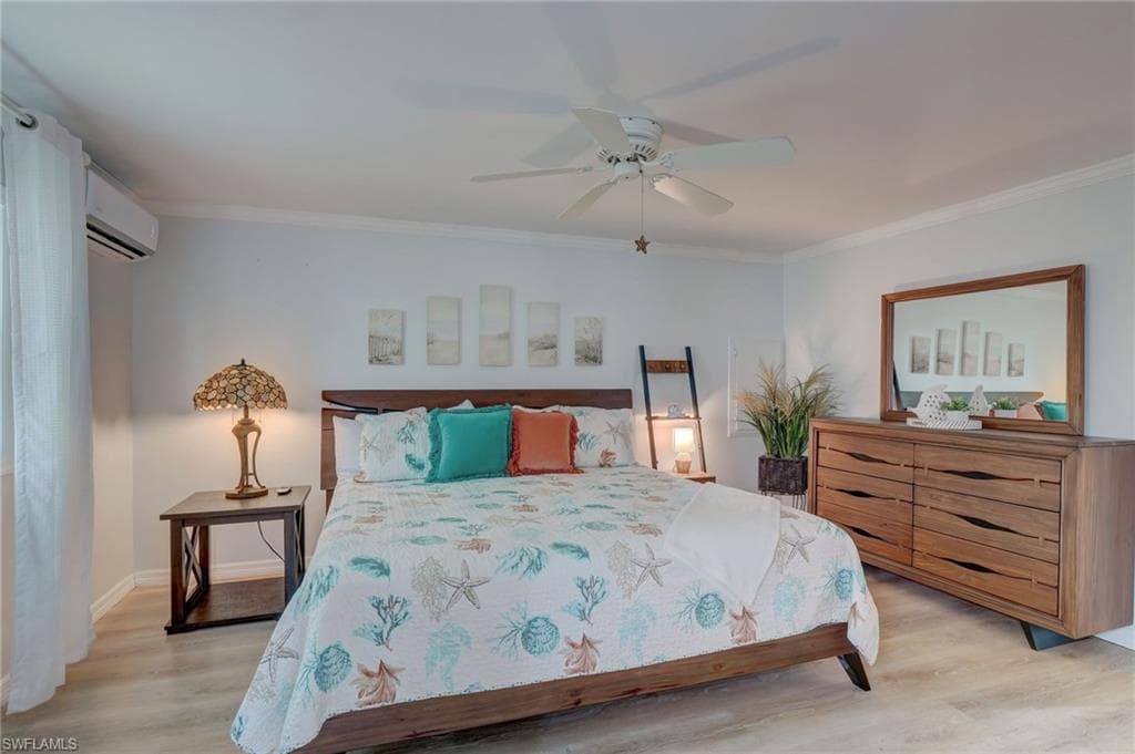 Bedroom with light wood finished floors, a ceiling fan, and ornamental molding