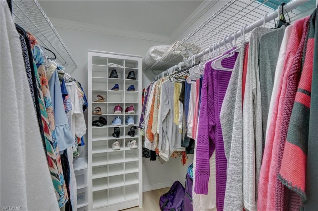Walk in closet with light wood-style floors