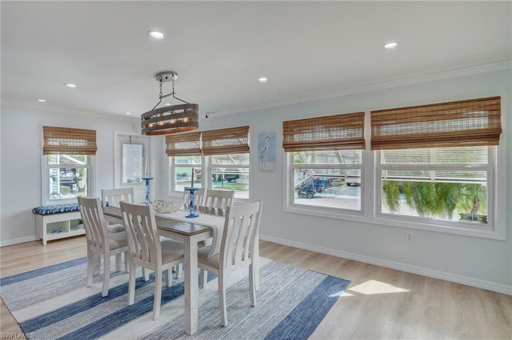 Dining space featuring light wood-style flooring, recessed lighting, and ornamental molding