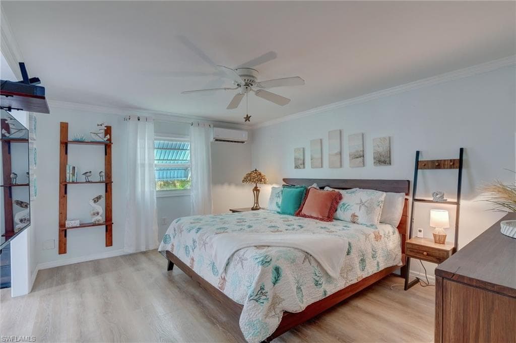 Bedroom featuring light wood finished floors, ceiling fan, and ornamental molding