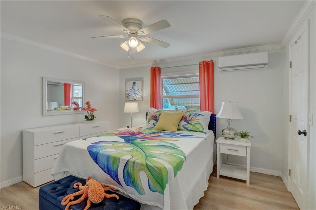 Bedroom featuring light wood-style flooring, multiple windows, ceiling fan, and crown molding