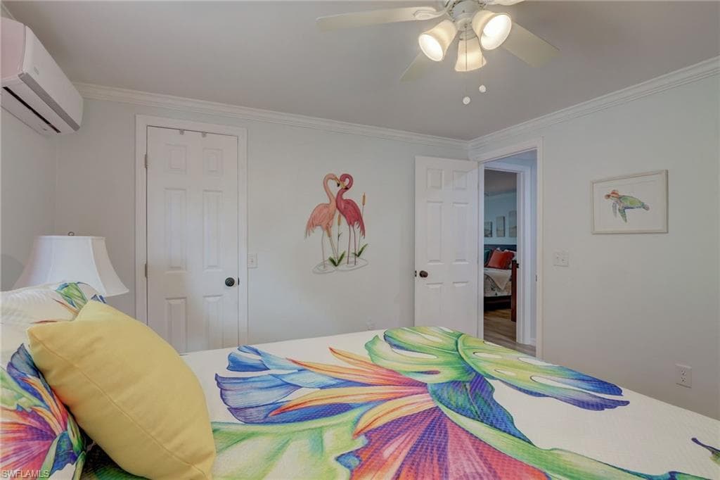 Bedroom featuring a mini split for heating / cooling, crown molding, and a ceiling fan
