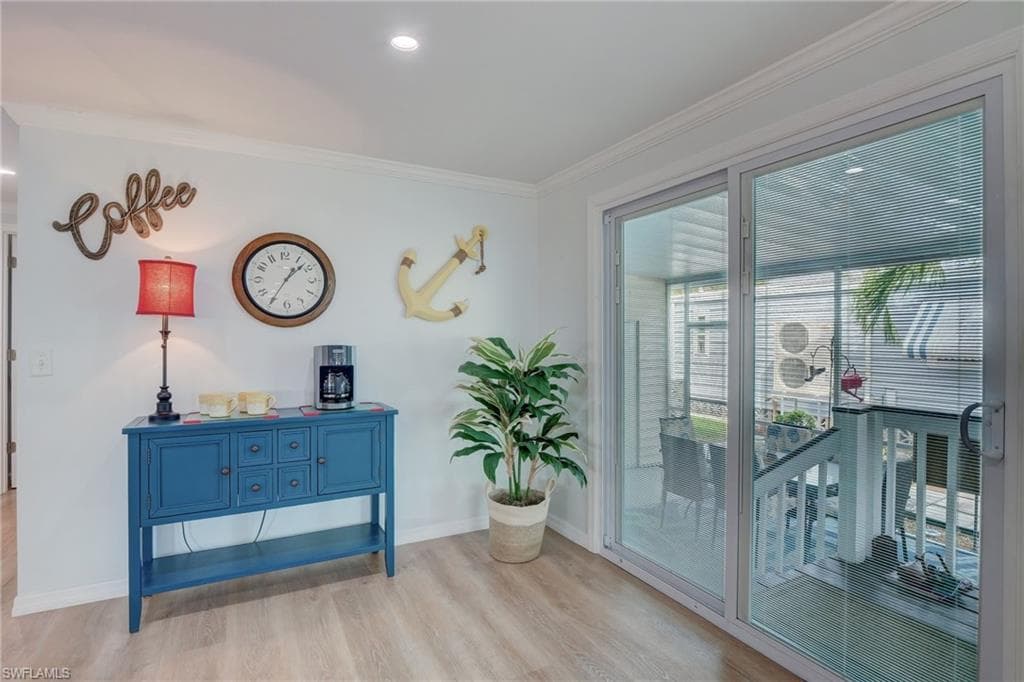 Living area with light wood-type flooring and ornamental molding