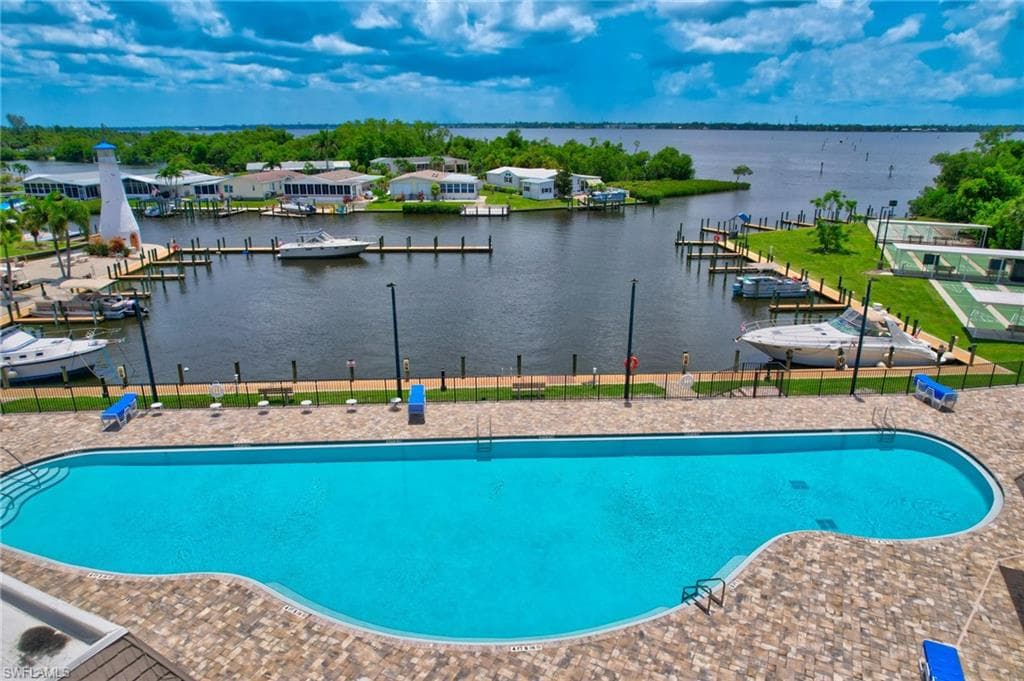 Community pool with a dock and a water view