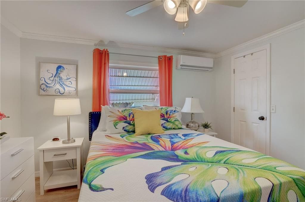 Bedroom featuring ceiling fan, crown molding, and wood finished floors