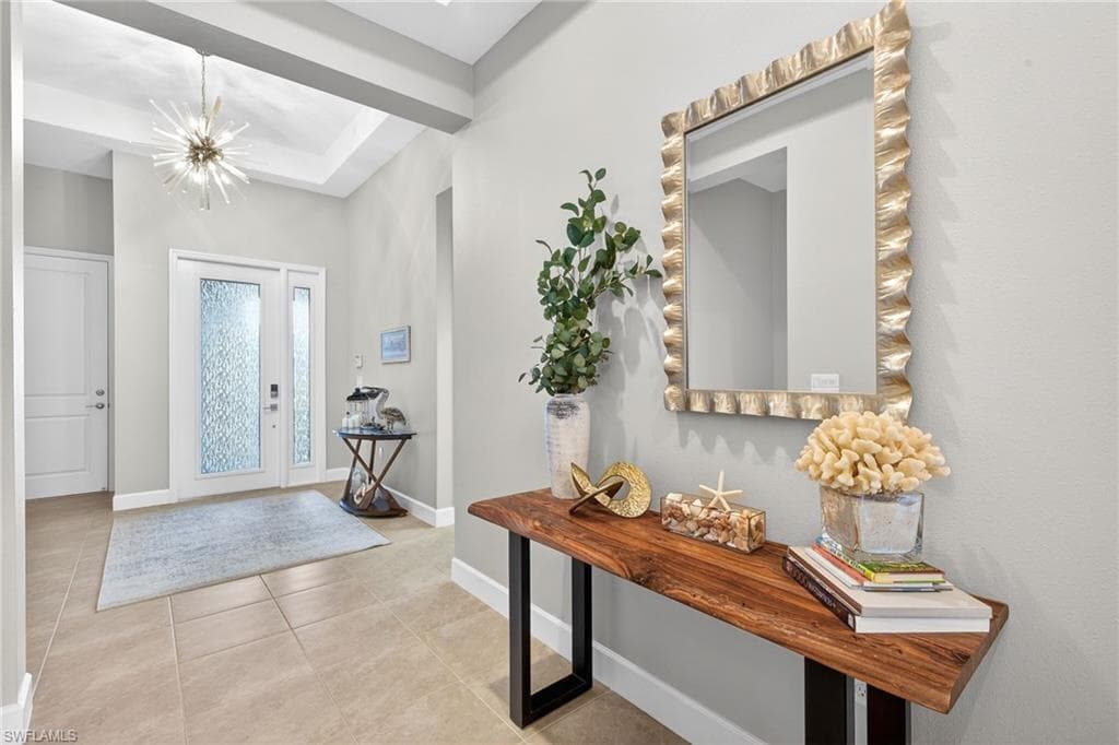 Upscale chandelier in grand foyer! Looonnnggg hallway with double coffered ceiling leads to fab pool area!