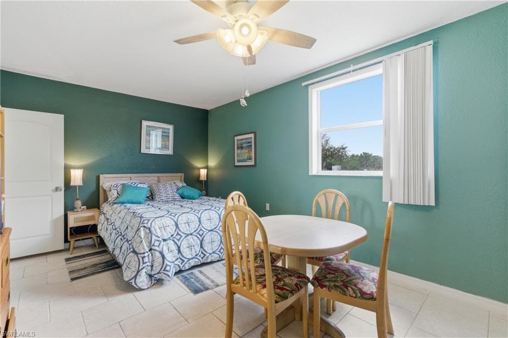 Bedroom with ceiling fan and light tile patterned floors