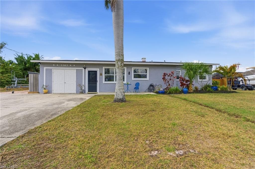 Single story home featuring stucco siding, a front lawn, and a patio