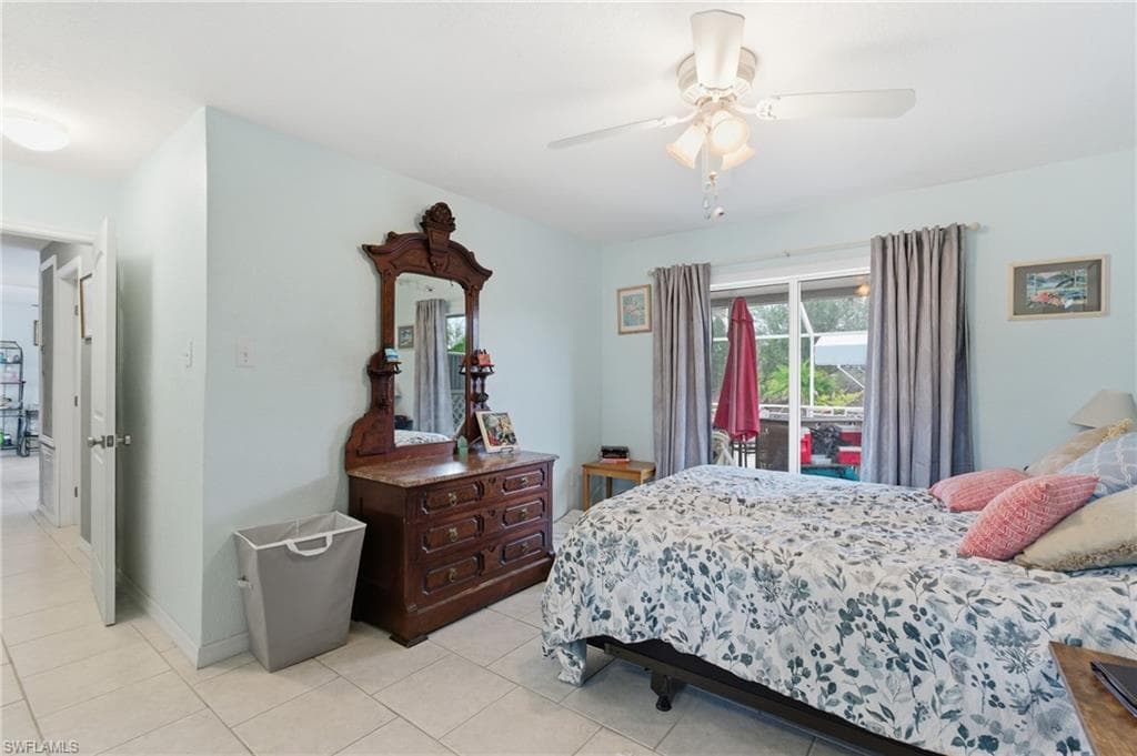 Bedroom featuring access to exterior, ceiling fan, and light tile patterned flooring