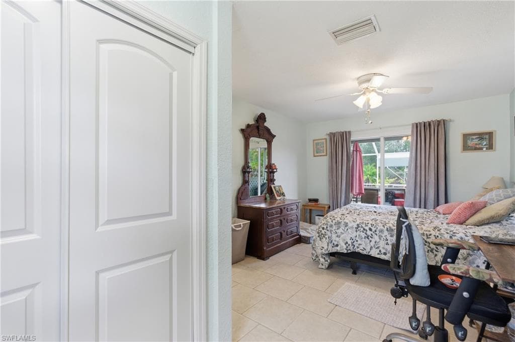 Bedroom with light tile patterned floors and ceiling fan