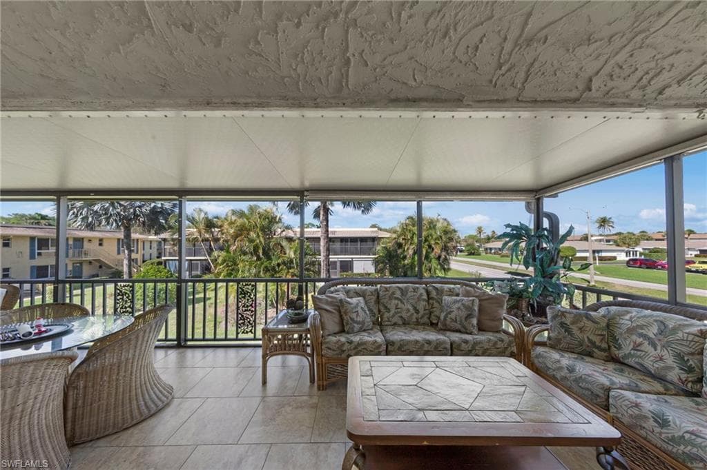Sunroom / solarium with a residential view and tile patterned flooring