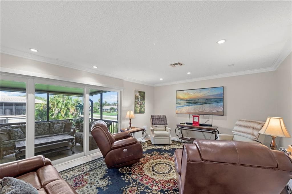 Living room with ornamental molding and recessed lighting