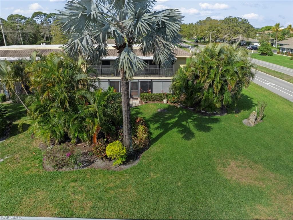 View of green lawn featuring a balcony