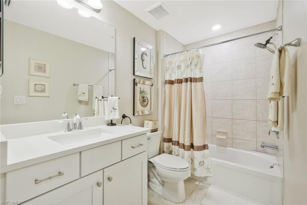 Full bathroom featuring vanity, shower / tub combo with curtain, and light tile patterned floors