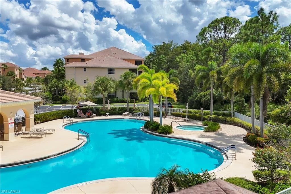Community pool featuring a patio and a hot tub