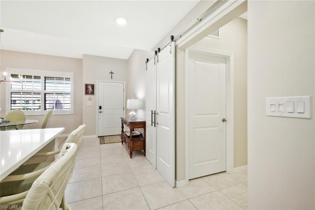 Hall featuring a barn door and light tile patterned floors