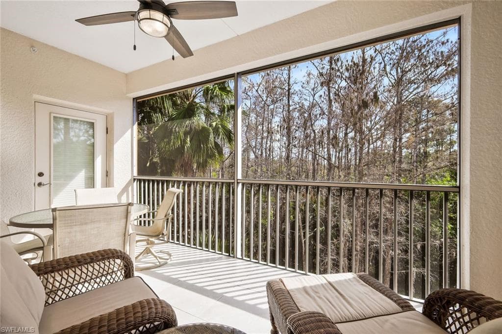 Sunroom / solarium with a ceiling fan, a balcony, and outdoor dining area