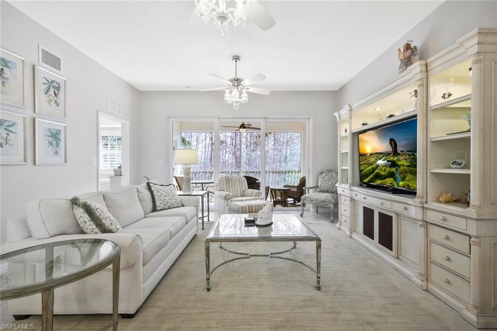 Living room with ceiling fan, plenty of natural light, and light carpet