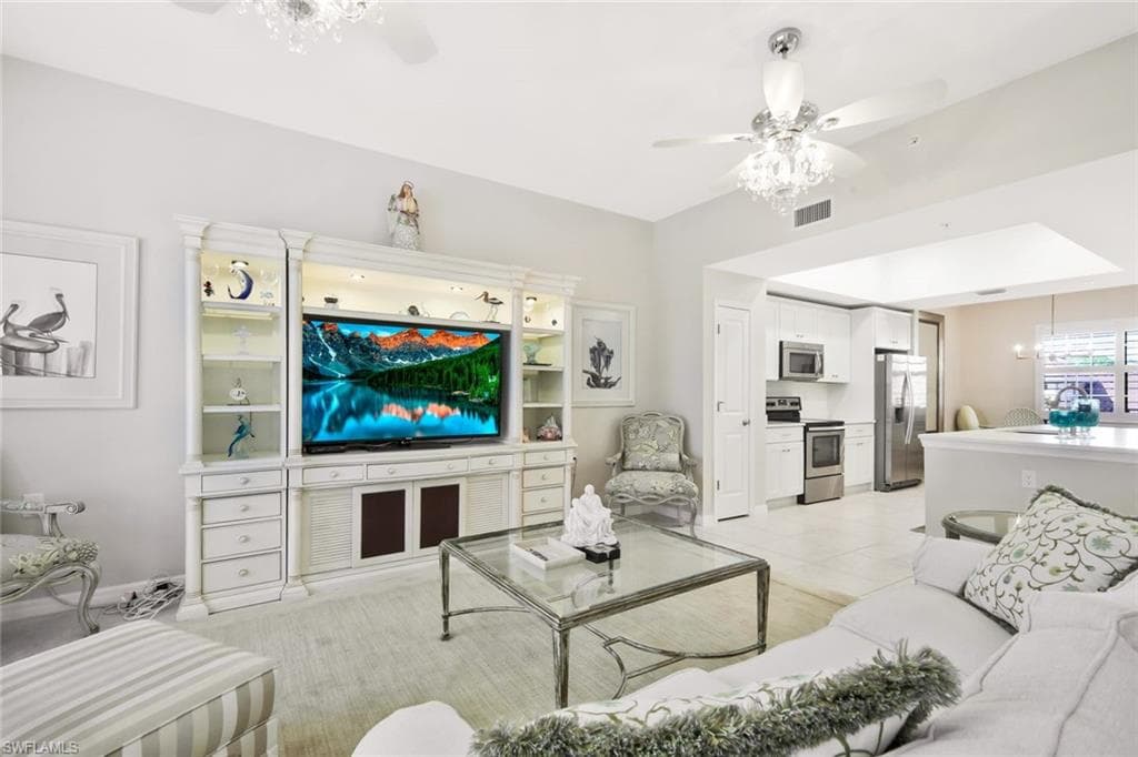 Living area featuring a ceiling fan, hanging lights, and light tile patterned floors