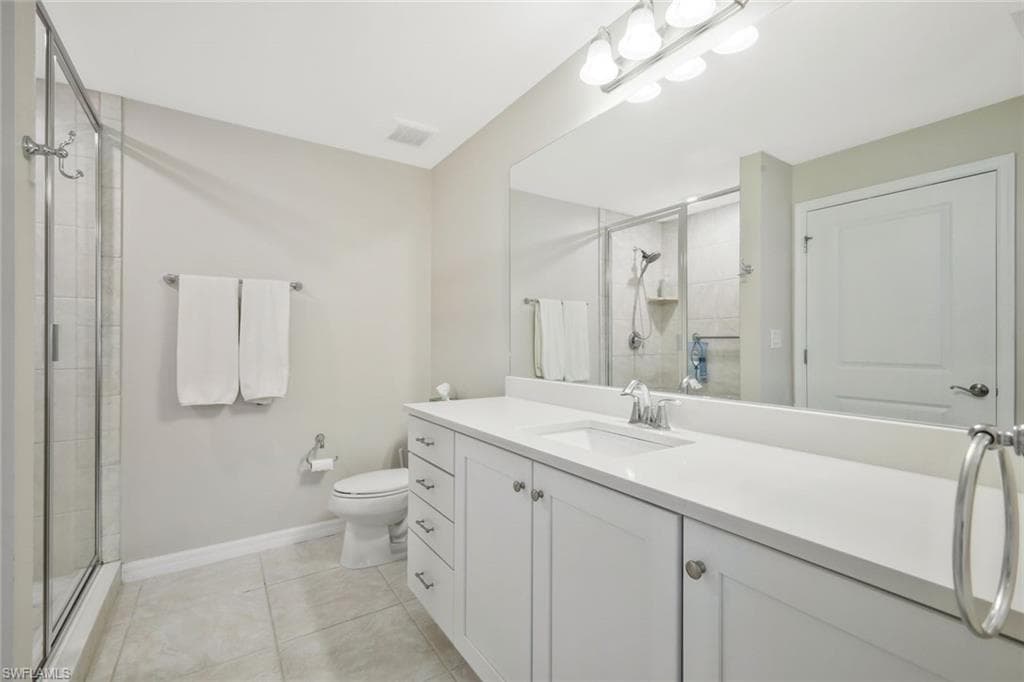 Bathroom with vanity, a shower stall, and light tile patterned flooring