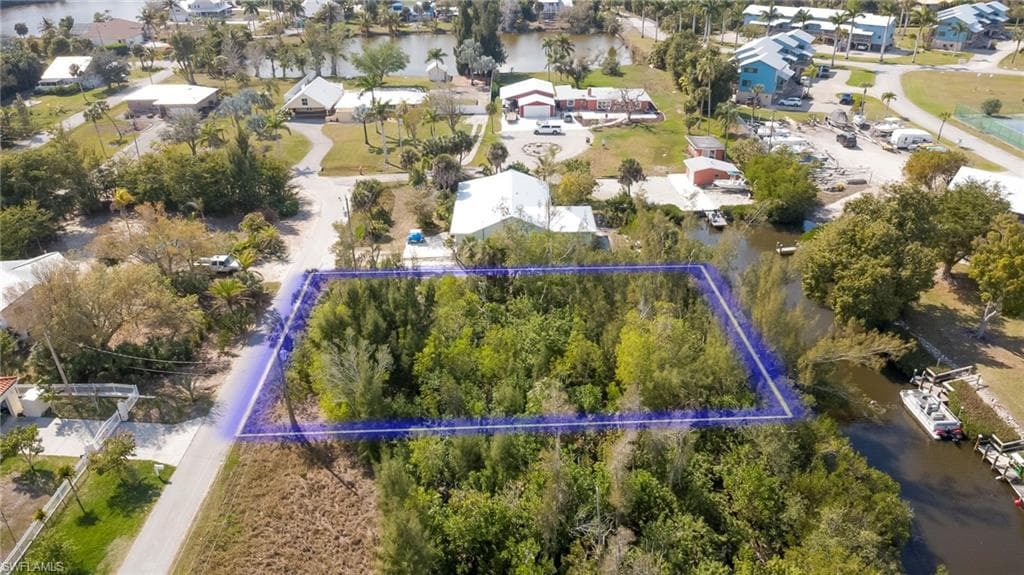 Aerial view of residential area featuring property parcel outlined and a large body of water