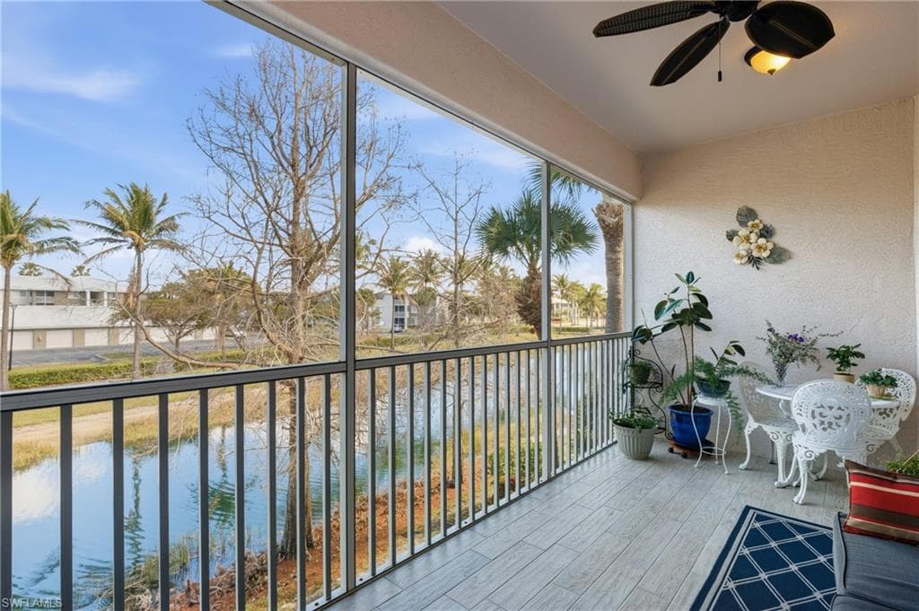 Sunroom featuring a textured wall, wood finished floors, and a water view