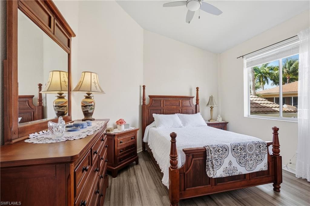 Bedroom featuring vaulted ceiling, dark wood-style flooring, and a ceiling fan