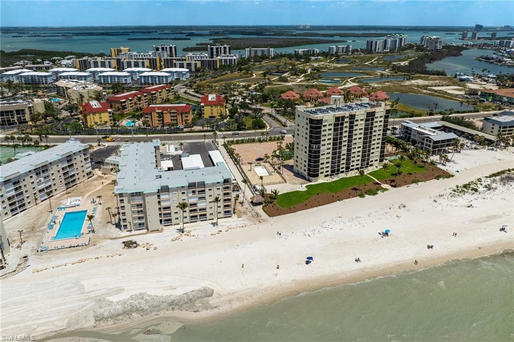 View of urban area featuring waterfront with a beach