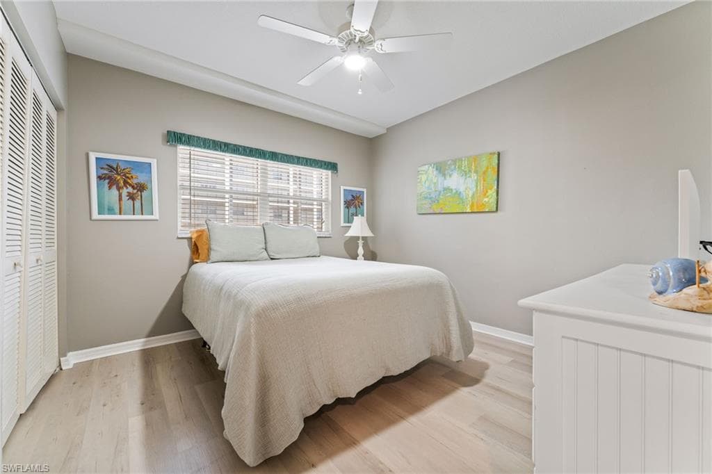 Bedroom featuring a closet, light wood finished floors, and a ceiling fan