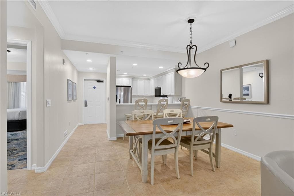 Dining room with crown molding and recessed lighting