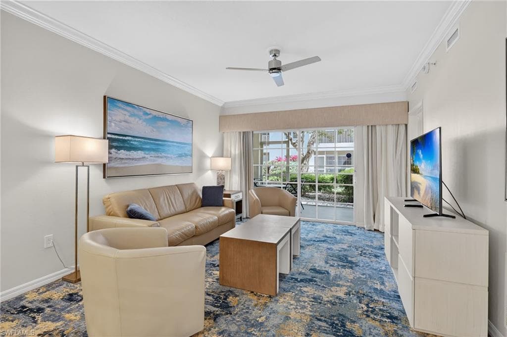 Living room with ornamental molding and a ceiling fan