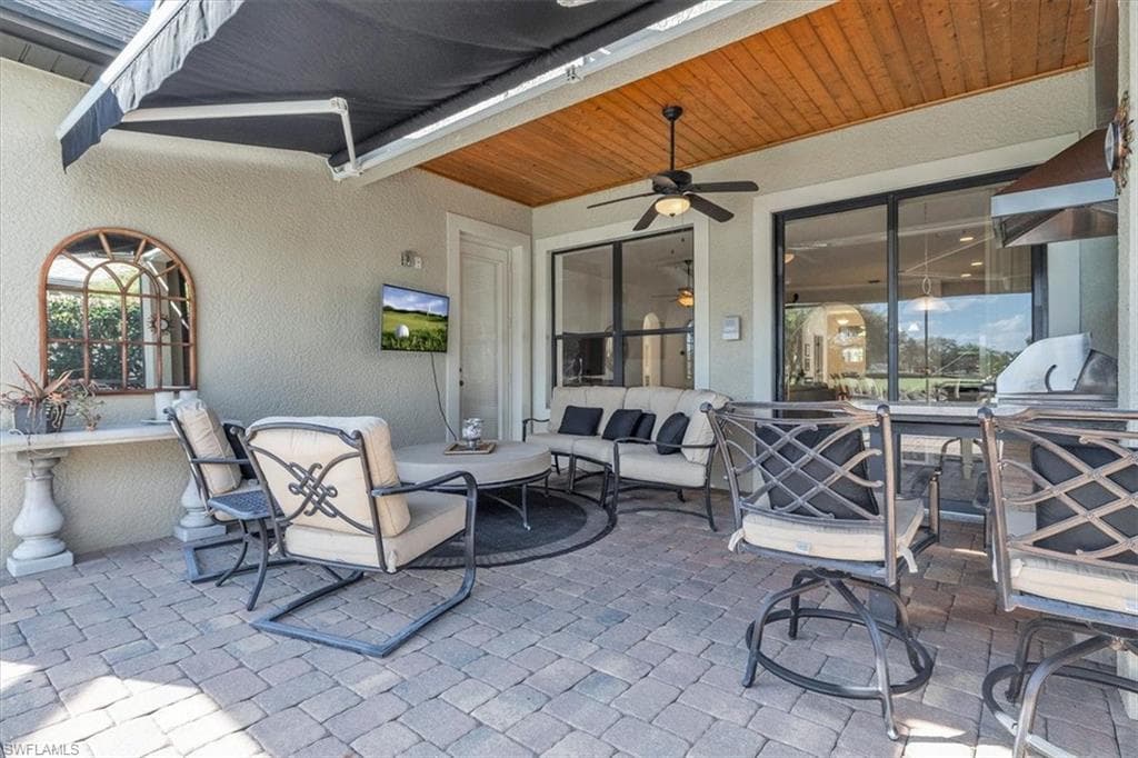 Lanai with wood inlays in the ceiling, outdoor kitchen, and retractable awning