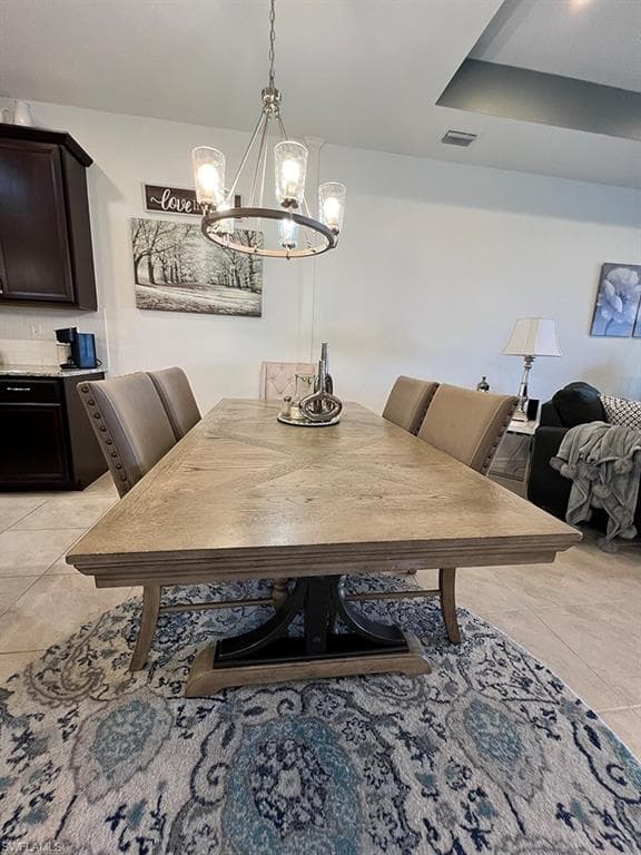 Dining space featuring hanging lights and light tile patterned floors