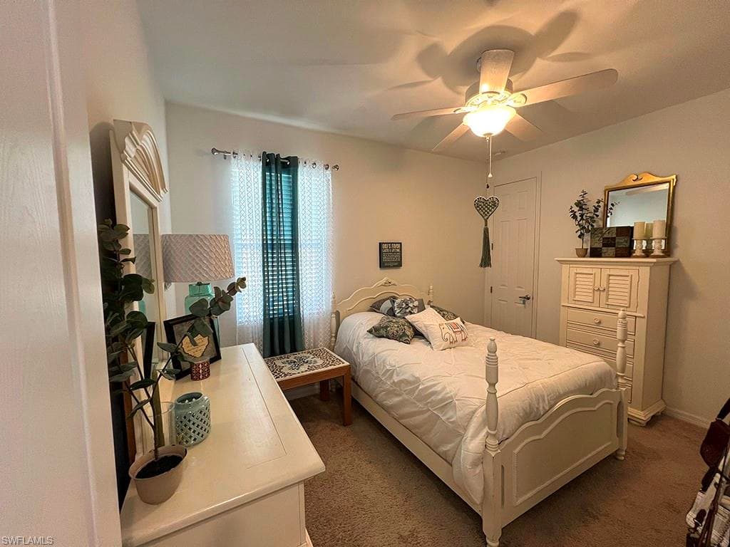 Bedroom with dark colored carpet and a ceiling fan