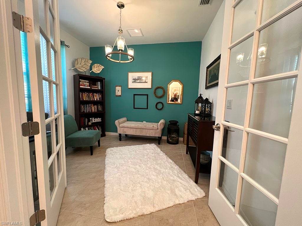 Home office featuring french doors, suspended lighting, and light tile patterned flooring