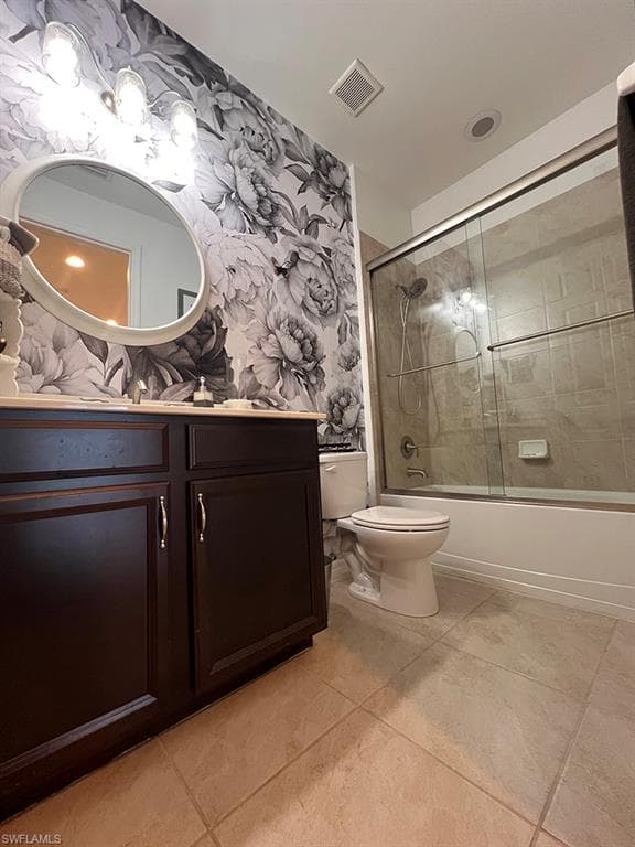 Full bath featuring vanity, shower / bath combination with glass door, wallpapered walls, and light tile patterned floors