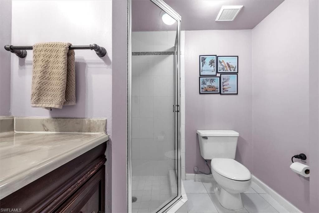 Bathroom with vanity, a stall shower, and light tile patterned floors