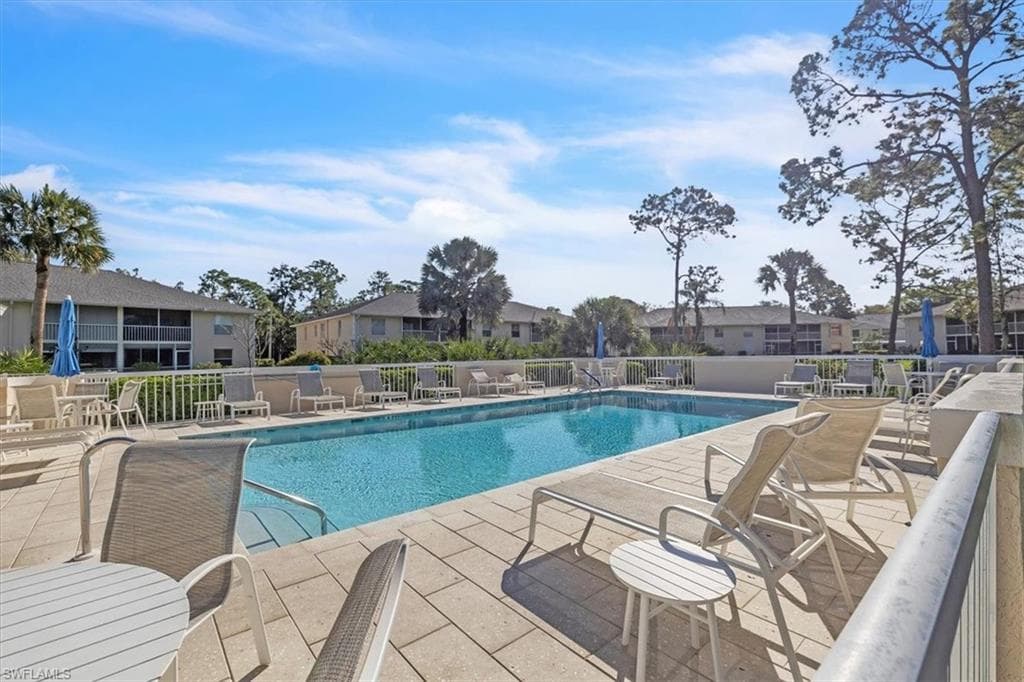 Community pool featuring a patio area and a residential view
