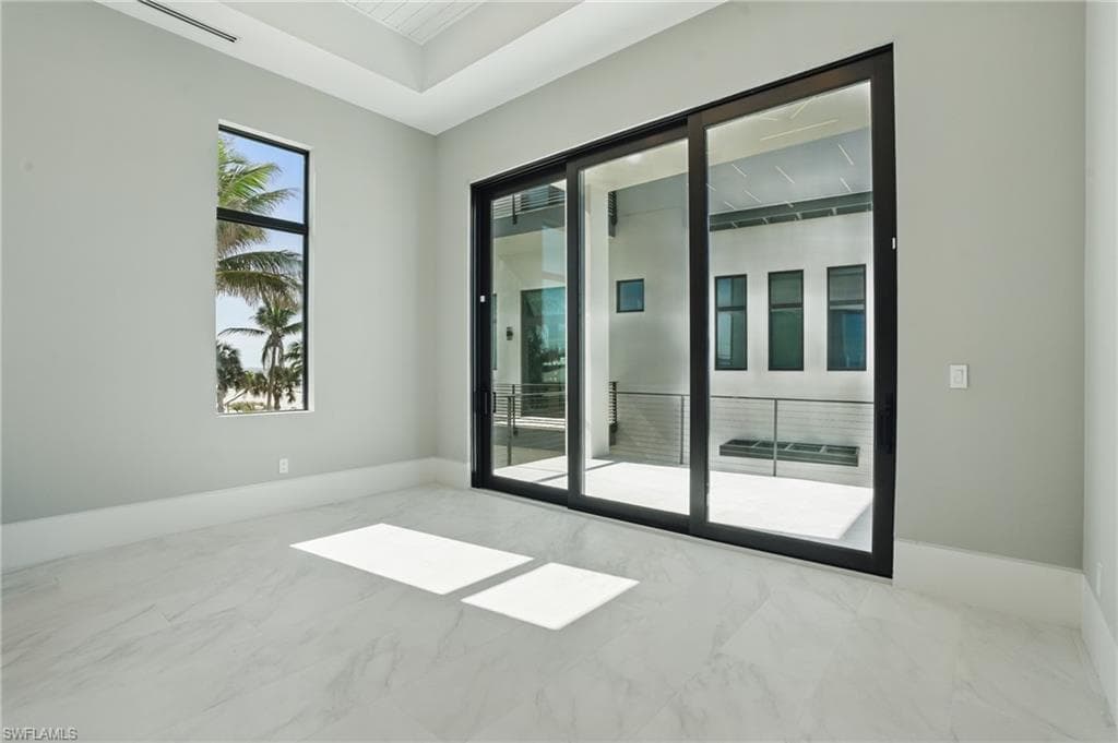 Empty room featuring baseboards and light marble finish flooring Virtually Enhanced