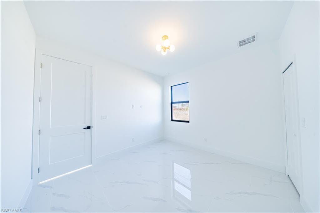 Spare room featuring light marble finish flooring