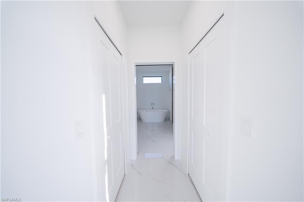 Corridor featuring light marble finish flooring