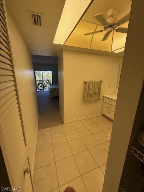 Corridor featuring baseboards and light tile patterned flooring