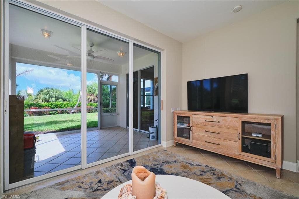 Living area featuring a ceiling fan and light tile patterned floors