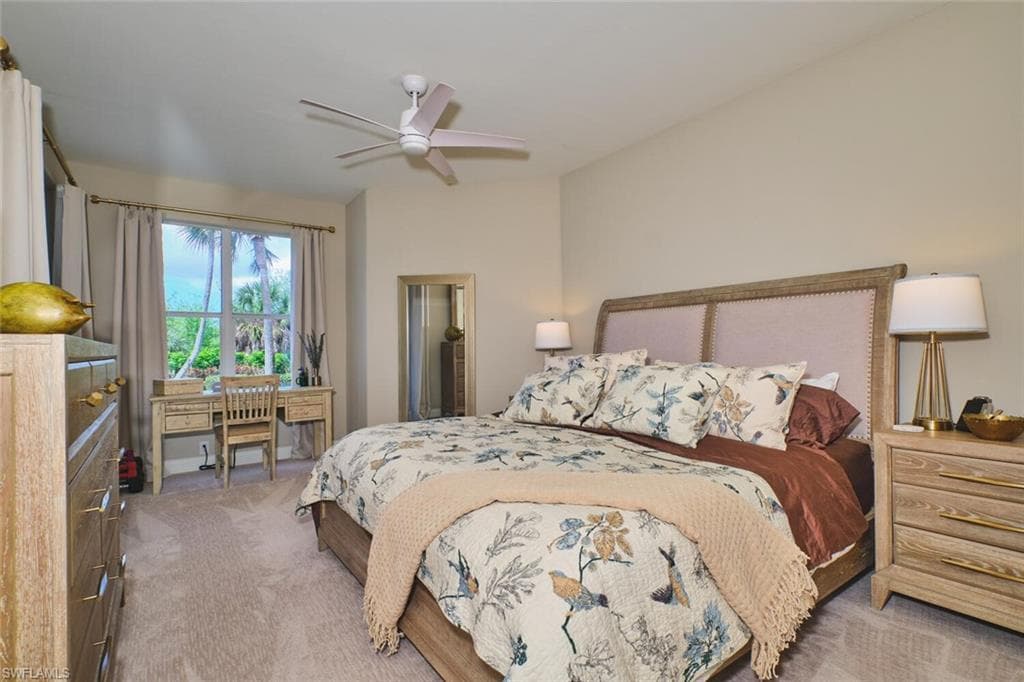 Carpeted bedroom featuring a ceiling fan