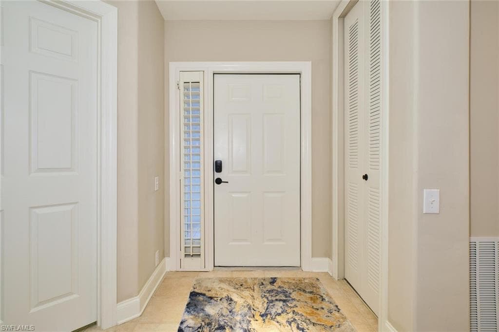 Foyer with baseboards and light tile patterned floors