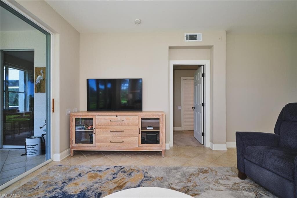 Living room featuring baseboards and light tile patterned flooring