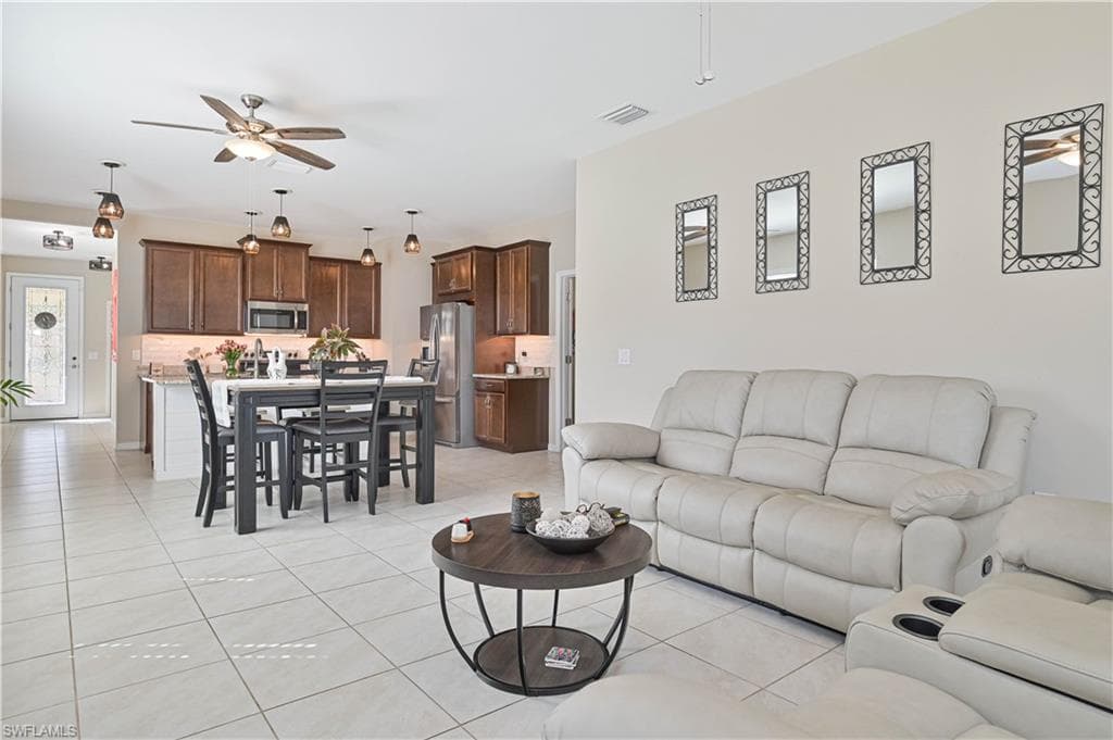 Living area featuring a ceiling fan and light tile patterned floors